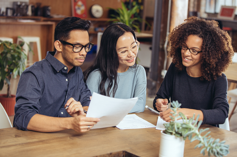 Image of three people reviewing documents