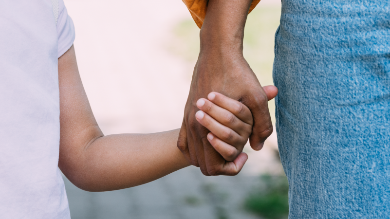 Image of child and parent holding hands